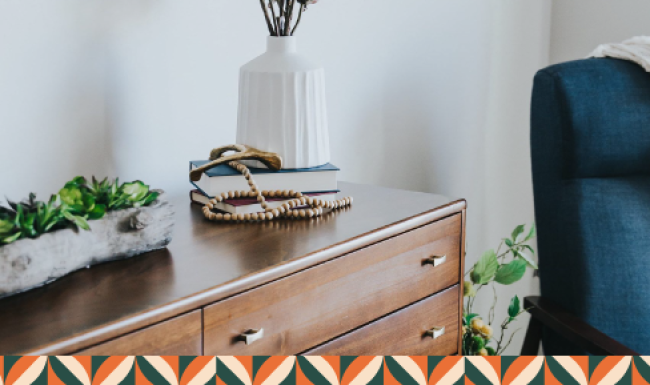 a dresser with a vase of plants on top