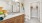 primary bathroom with large closet, floor to ceiling glass shower enclosure with subway tile, quartz countertops, under mount sink and custom wood cabinetry